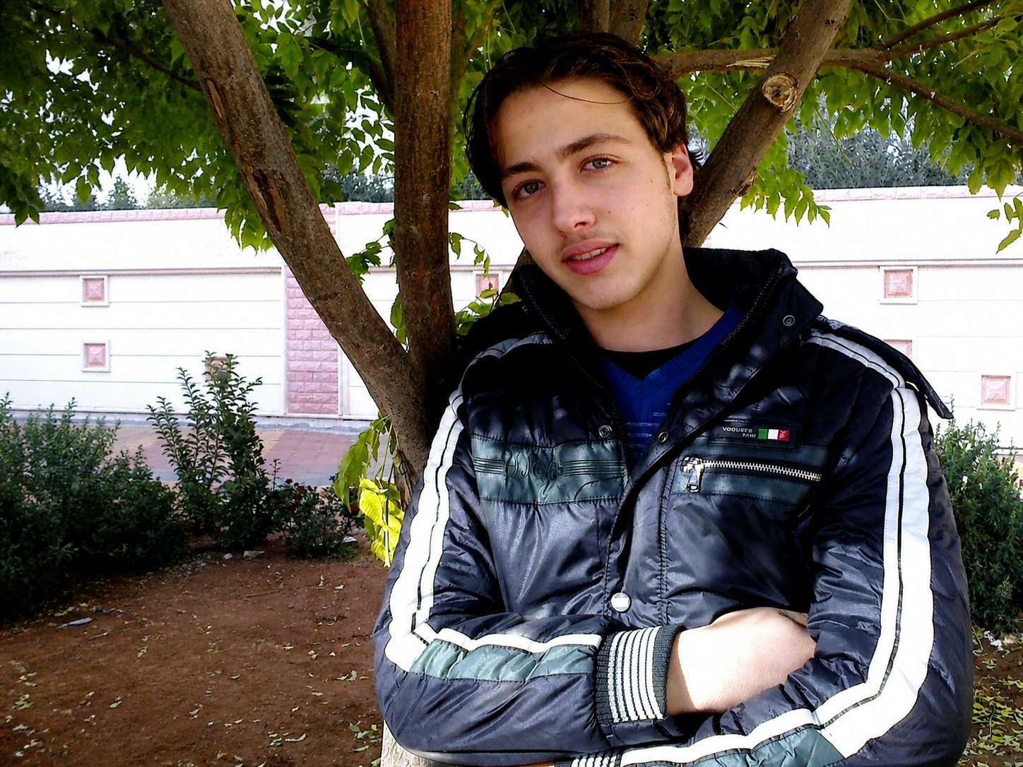 Teenage Basel sitting under a tree in southern Syria.